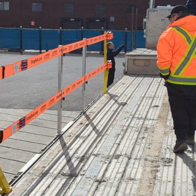 TrukRail provides fall protection for a worker on a flatbed truck.